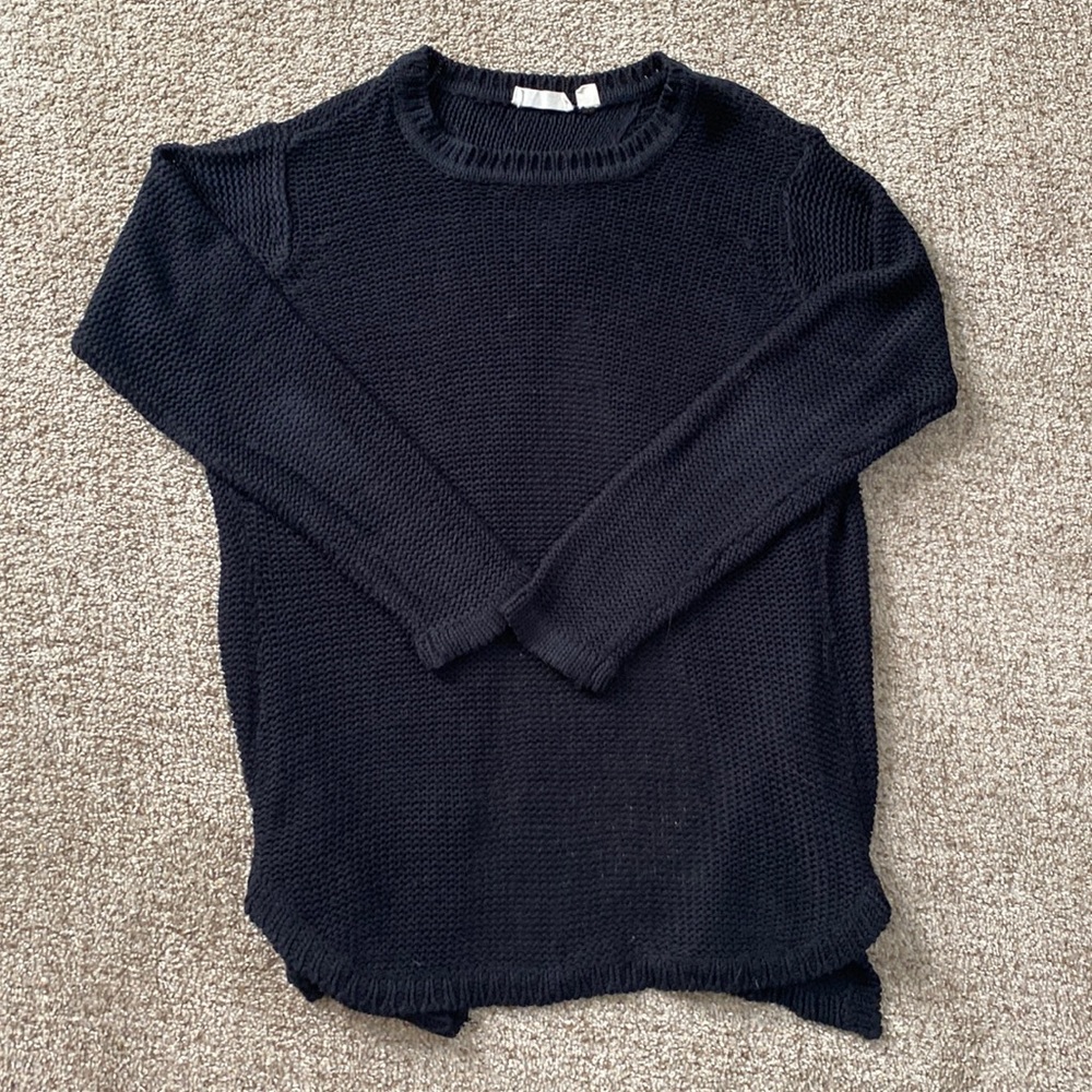 Black sweater with open back detail.